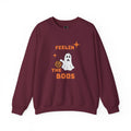 A maroon crewneck sweatshirt featuring a Halloween graphic with the text 'FEELIN THE BOOS' in orange, a white ghost, and an orange pumpkin, displayed on a clean white background.