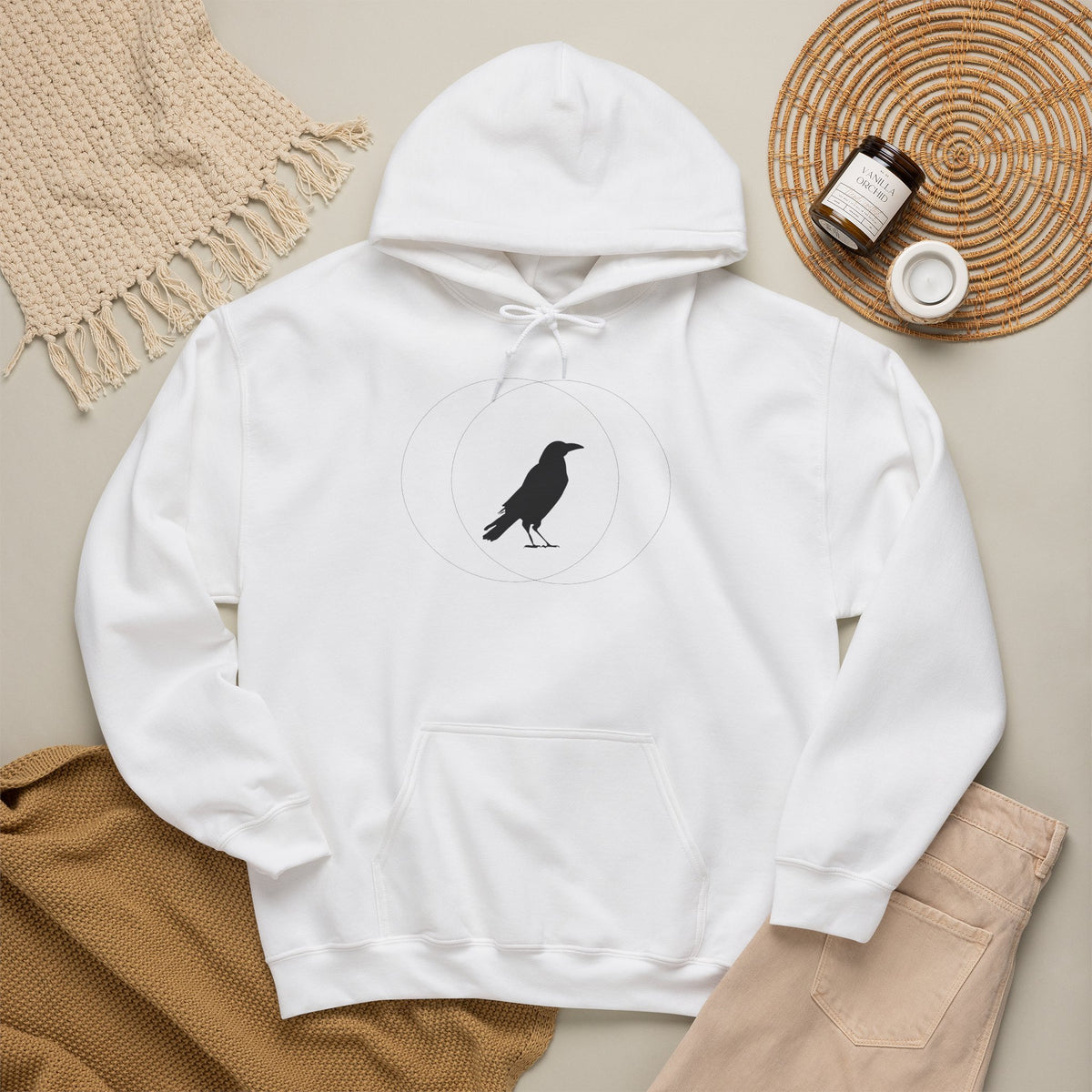 White Wise Crow hoodie laid flat with a knit hat and coffee