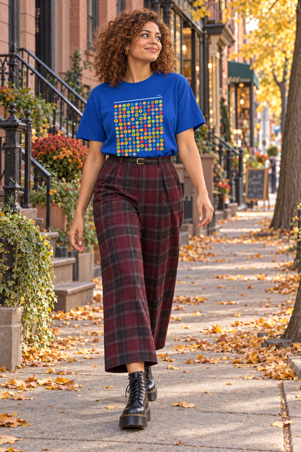 Woman wearing a blue NYC Word Search shirt and plaid skirt on a sidewalk