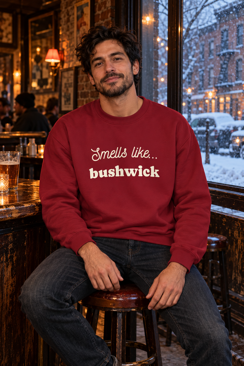 Man wearing a burgundy Smells Like Bushwick sweatshirt outside a bar