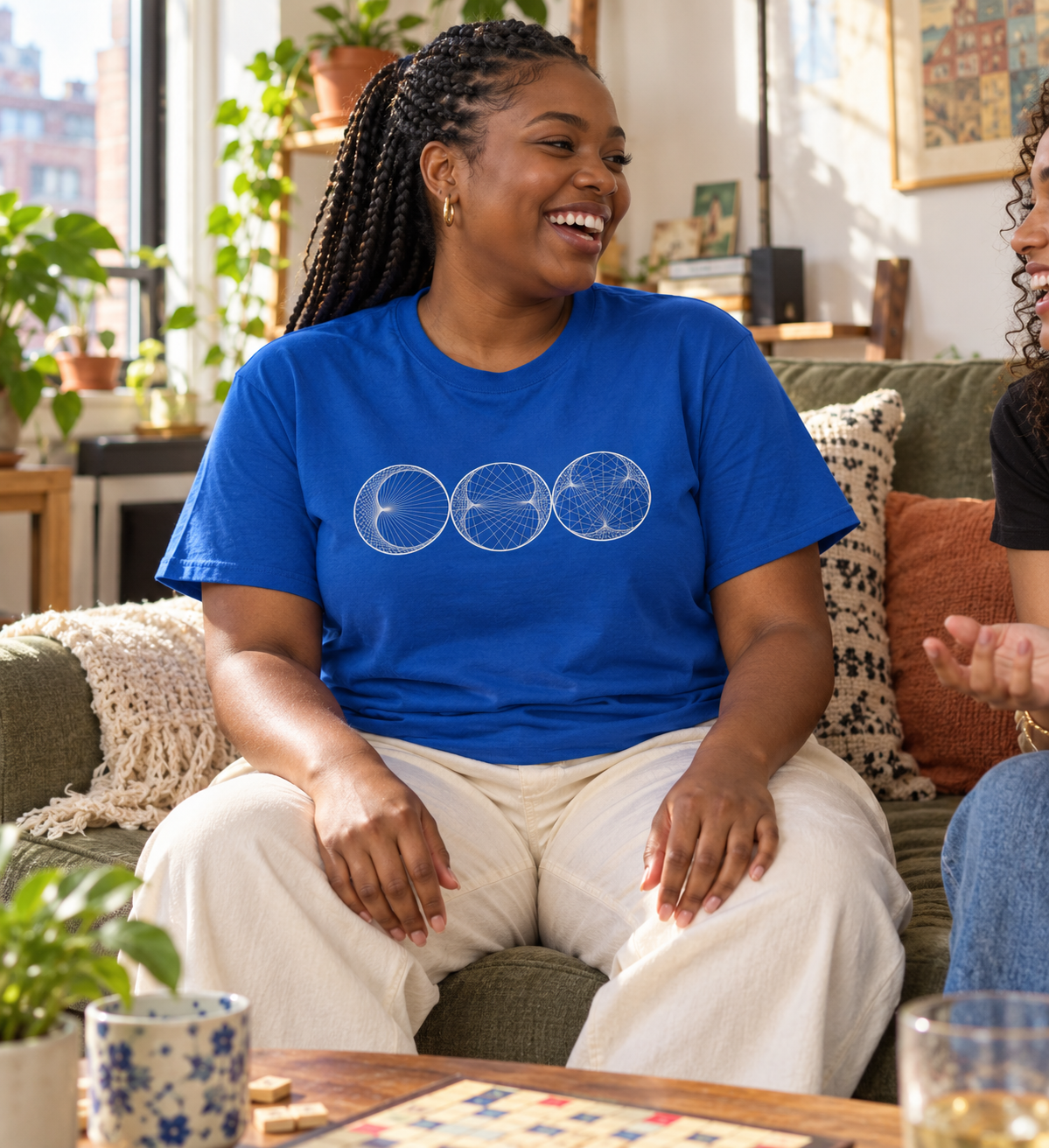 Woman wearing a royal blue Cycloids shirt while sitting on a sofa