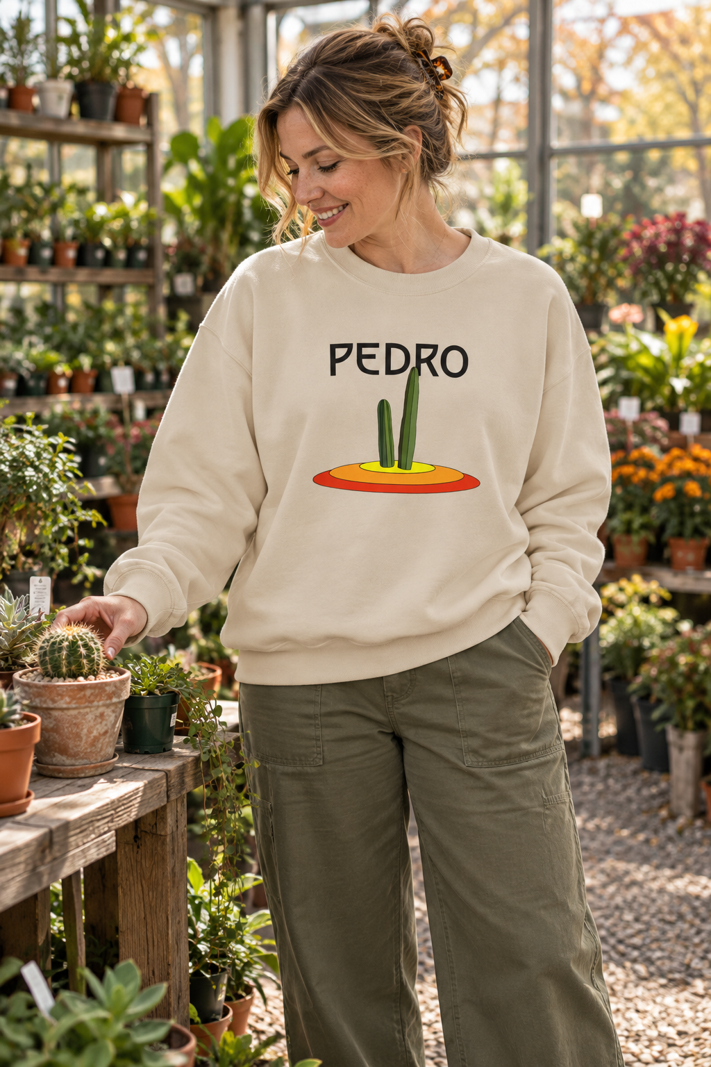 Woman wearing a cream Pedro Cactus sweatshirt in a plant shop