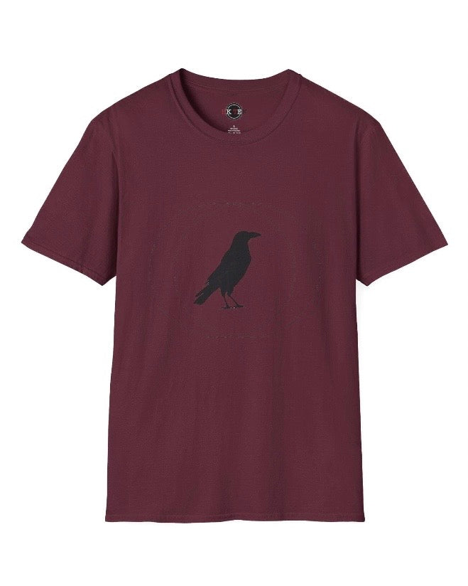 A maroon short-sleeve crewneck t-shirt featuring a black crow silhouette printed on the chest, displayed against a solid white background.