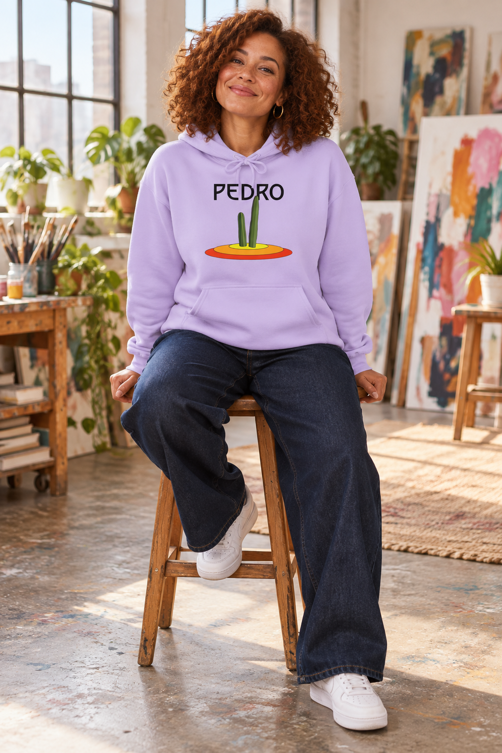 Woman wearing a lavender Pedro Cactus hoodie while sitting on a stool