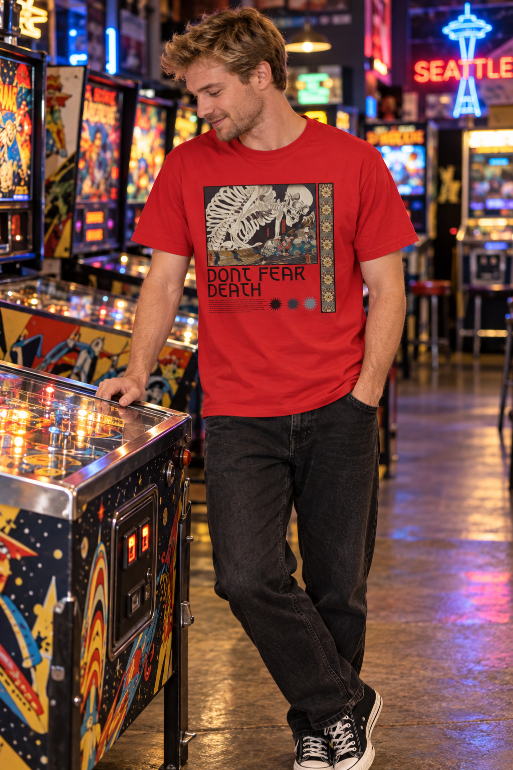 Man wearing a red Don't Fear Death shirt beside pinball machines
