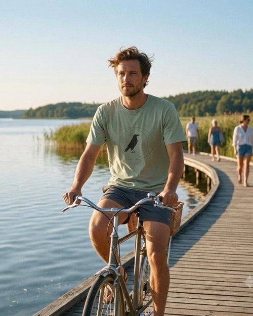 Sage Wise Crow T-shirt worn beside a lake