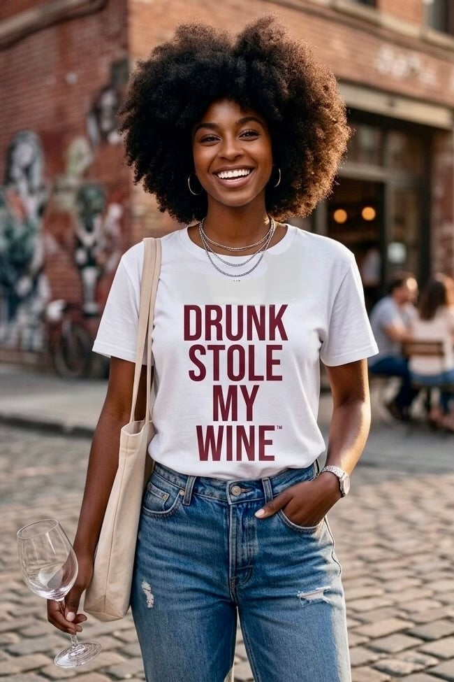 Woman wearing a white Drunk Stole My Wine shirt on a sidewalk