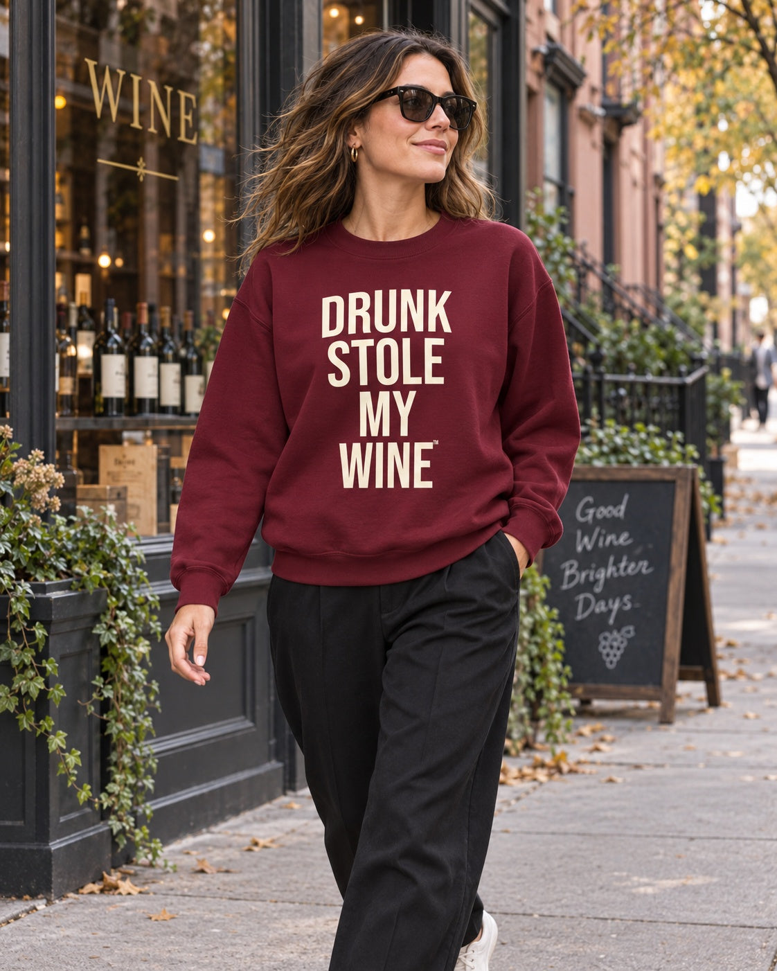 Woman wearing the Garnet Drunk Stole My Wine sweatshirt outside a wine shop