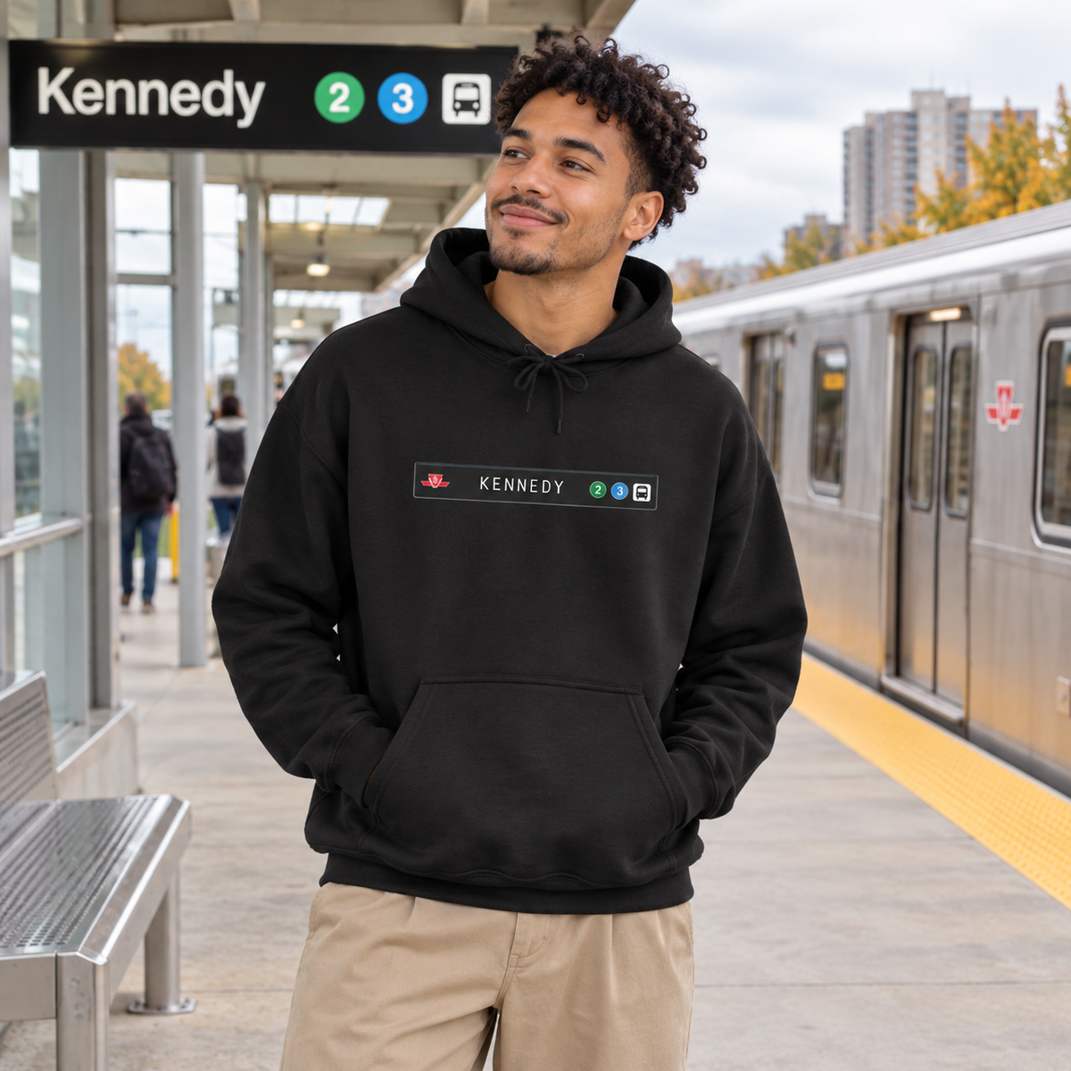 Man wearing a black Kennedy Scarborough RT hoodie at a train platform