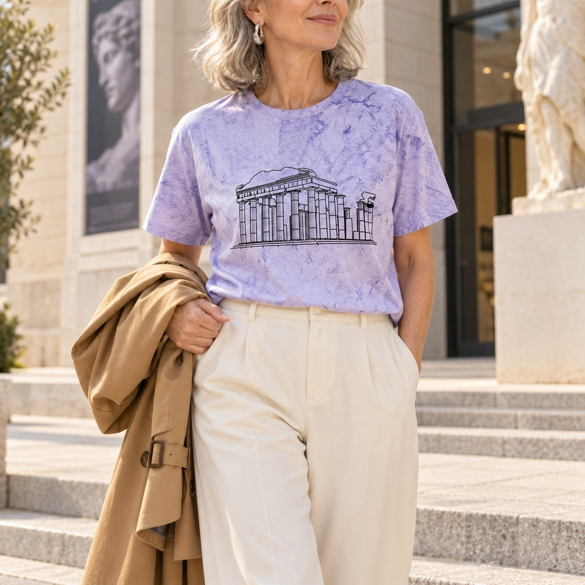 Woman wearing a purple tie-dye Roman Ruins shirt outside a building